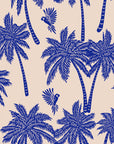 Tropical palm tree wallpaper pattern with hand illustrated palm trees and birds in deep blue on a warm neutral background.