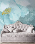 Aqua and gold watercolor Blue Daydreams peel and stick wallpaper behind elegant tufted daybed
