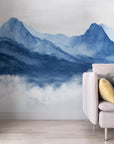 Navy and light blue watercolor mountain mural wallpaper in modern living room with clouds