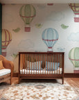 Playful bluebirds and retro-style hot air balloons soar across the background of this baby room