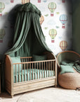 The design element for this infant's space is a classic aesthetic featuring delightful hot air craft and songbirds soaring.