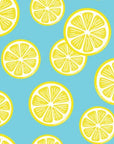 Greenery and vivid yellow citrus fruits are arranged flowing diagonally across the white space
