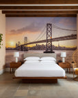 San Francisco Bay Bridge at sunset mural wallpaper behind mid-century modern bedroom with wooden beams