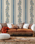 Self-adhesive wall covering featuring cream and blue vertical stripes overlaid with a botanical vine pattern. Product name: Ethereal Stripes