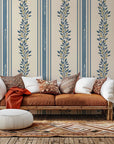 Self-adhesive wall covering featuring cream and blue vertical stripes overlaid with a botanical vine pattern. Product name: Ethereal Stripes
