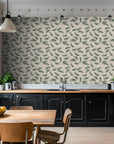 Palm leaves strewn across a botanical print wallpaper