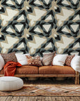 Peel and stick wallpaper featuring a modern geometric pattern of grey and beige triangles, called Fractured Light