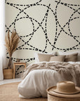 Self-adhesive wallpaper featuring the 'Fragmented Orbit' pattern of segmented, cream and black, curved geometric lines