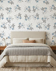 Frost Berry removable wallpaper with blue berries and gray leaves on cream background in serene bedroom