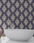 Navy and cream Gentlebotan damask wallpaper behind modern white bathtub in elegant bathroom setting