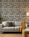 Gridded Scrawl black and beige abstract geometric square wallpaper in a warm and inviting living room