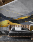 Abstract mountain landscape mural with gold and charcoal layers on modern bedroom accent wall