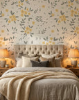 Lemon Grove floral wallpaper with golden yellow blooms and sage leaves on cream background in cozy bedroom