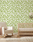 Green and cream Lime Bloom peel and stick wallpaper in modern nursery with natural wood crib
