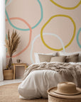 Soft yellow and pastel pink self-adhesive wallcovering featuring an abstract looping pattern, called Loop Dreams