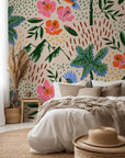 A lush wall covering by Lush Notion, printed with parrots, palm fronds, and hibiscus blossoms on a peach background