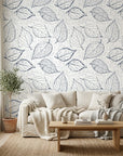 Midnight Fossil peel and stick wallpaper with navy leaf sketches on cream linen-textured background in cozy living room