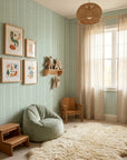 Mint Morse geometric stripe wallpaper in sage green nursery with natural wood accents