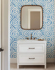 A repeating blue lattice pattern formed by hand-drawn geometric diamond motifs on a crisp white wall covering, rendered in a delicate watercolor and porcelain style