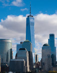 Modern Rising cityscape wallpaper featuring blue glass skyscrapers against dramatic cloudy sky