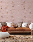 A peel and stick wallpaper featuring a geometric ogee pattern in shimmering rose gold and rosy pink tones