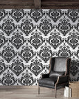 Rosette Haven damask wallpaper on living room wall with black leather chair and rustic wood beams