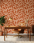 Rust Echoes bold leaf wallpaper as a feature wall in a bright home office