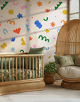 Modern abstract wallpaper styled in a kid room, creating a lighthearted design statement with whimsical shapes and muted pastels.