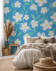 A white, chalk-style daisy pattern printed on deep blue wallpaper