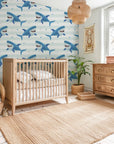 Peel-and-stick wall art featuring light blue shark silhouettes gliding across a backdrop of faint aquatic stripes. - Smiling Jaws
