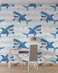 Self-adhesive wall covering featuring a repeating pattern of swimming sharks over a light blue striped oceanic background - Smiling Jaws