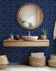 A deep navy blue wall covering patterned with pink stars and linear elements, known as Stellar Bloom