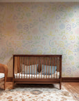 Contemporary ivory wallpaper adorned with tiny, colorful, undulating squiggles and spotted elements.