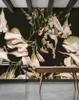Blush pink and cream botanical wallpaper featuring oversized flowers on dark background in modern office setting