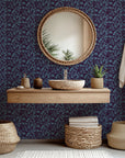 Deep violet wall covering displaying a blue, stylized floral vine motif (Twilight Bloom)