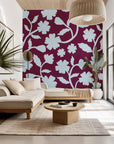 Velvet Bloom peel and stick wall covering, displaying a light blue floral silhouette on a striking burgundy background