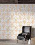 Gold and cream Victorian Petal Dream damask wallpaper in elegant living room with leather chair