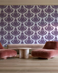 Antique Fern Mist Aubergine distressed damask wallpaper in a boutique hotel sitting area