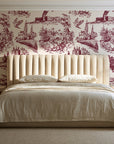 Arcadian Reverie Claret pastoral toile wallpaper behind a channel-tufted bed in a calm primary bedroom