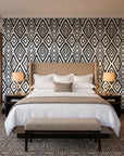 Aztec Quilt Espresso geometric tribal wallpaper behind the headboard of a king bed in a contemporary hotel guest room