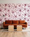 Blueprint Bloom Blush floral line wallpaper behind a rust velvet sofa in a bright coworking lounge