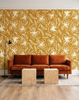 Blueprint Bloom Ochre floral line wallpaper behind a rust velvet sofa in a bright coworking lounge