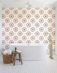 Captain's Wheel Burgundy nautical ship wheel wallpaper behind a freestanding tub in a bright coastal bathroom