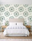 Captain's Wheel Evergreen nautical ship wheel wallpaper behind a queen bed in a bright coastal bedroom
