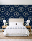 Captain's Wheel Midnight nautical ship wheel wallpaper behind a queen bed in a bright coastal bedroom
