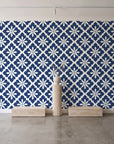 Carbon Bloom Navy tile floral wallpaper behind a travertine pedestal and vase in a minimal boutique