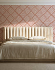 Chevron Etch Clay geometric diamond wallpaper behind a channel-tufted bed in a calm primary bedroom