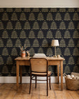 Clipped Dreams Noir tree wallpaper behind a vintage writing desk in a cozy craft-room home office