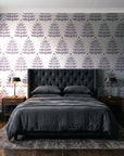 Clipped Dreams Plum tree wallpaper behind a tufted headboard in a dark, moody bedroom