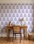 Clipped Dreams Plum tree wallpaper behind a vintage writing desk in a cozy craft-room home office